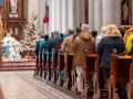 Ludzie siedzą w kościele przy choince. Czy w drugi dzień świąt trzeba iść do kościoła?