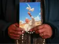 Dłonie trzymają obrazek z Papieżem Franciszkiem wypuszczającym gołębicę. To inspiracja z cytatów papieża franciszka.