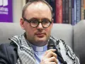 Ksiądz Kaczkowski, w okularach i z szalem, dzieli się cytatami o życiu.