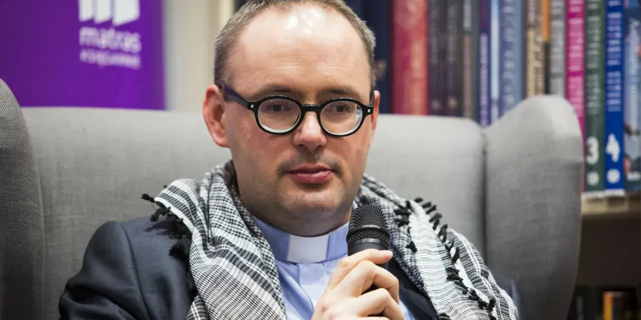 Ksiądz Kaczkowski, w okularach i z szalem, dzieli się cytatami o życiu.