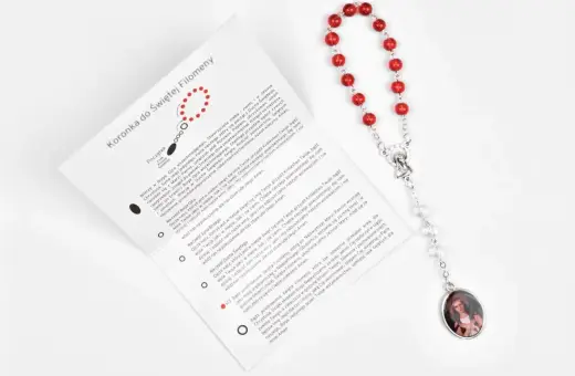 Modlitwa do św. Ekspedyta o szybką pomoc. Czerwona koronka z medalikiem Matki Bożej i instrukcją modlitwy.