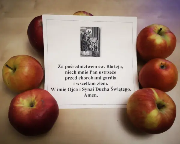 Jabłka otaczają kartkę z modlitwą do św. Błażeja o ochronę gardła.