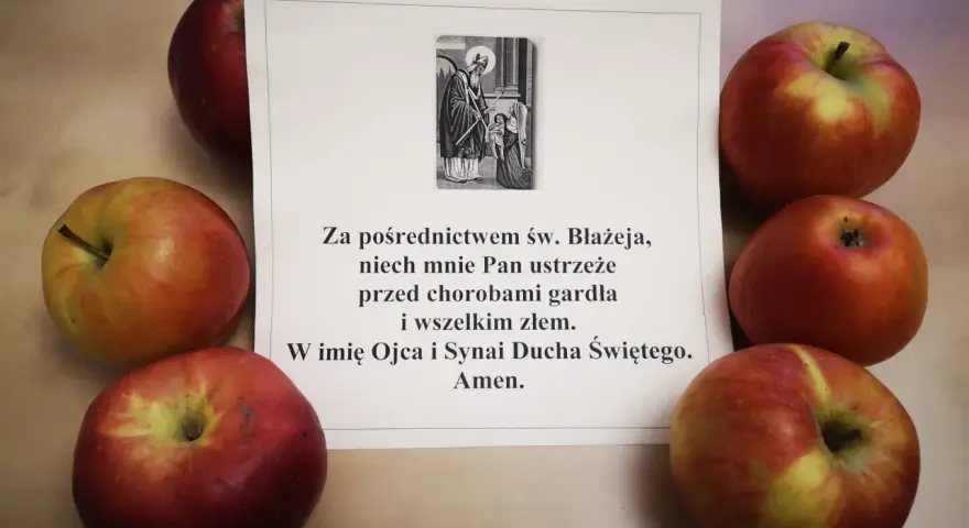 Jabłka otaczają kartkę z modlitwą do św. Błażeja o ochronę gardła.