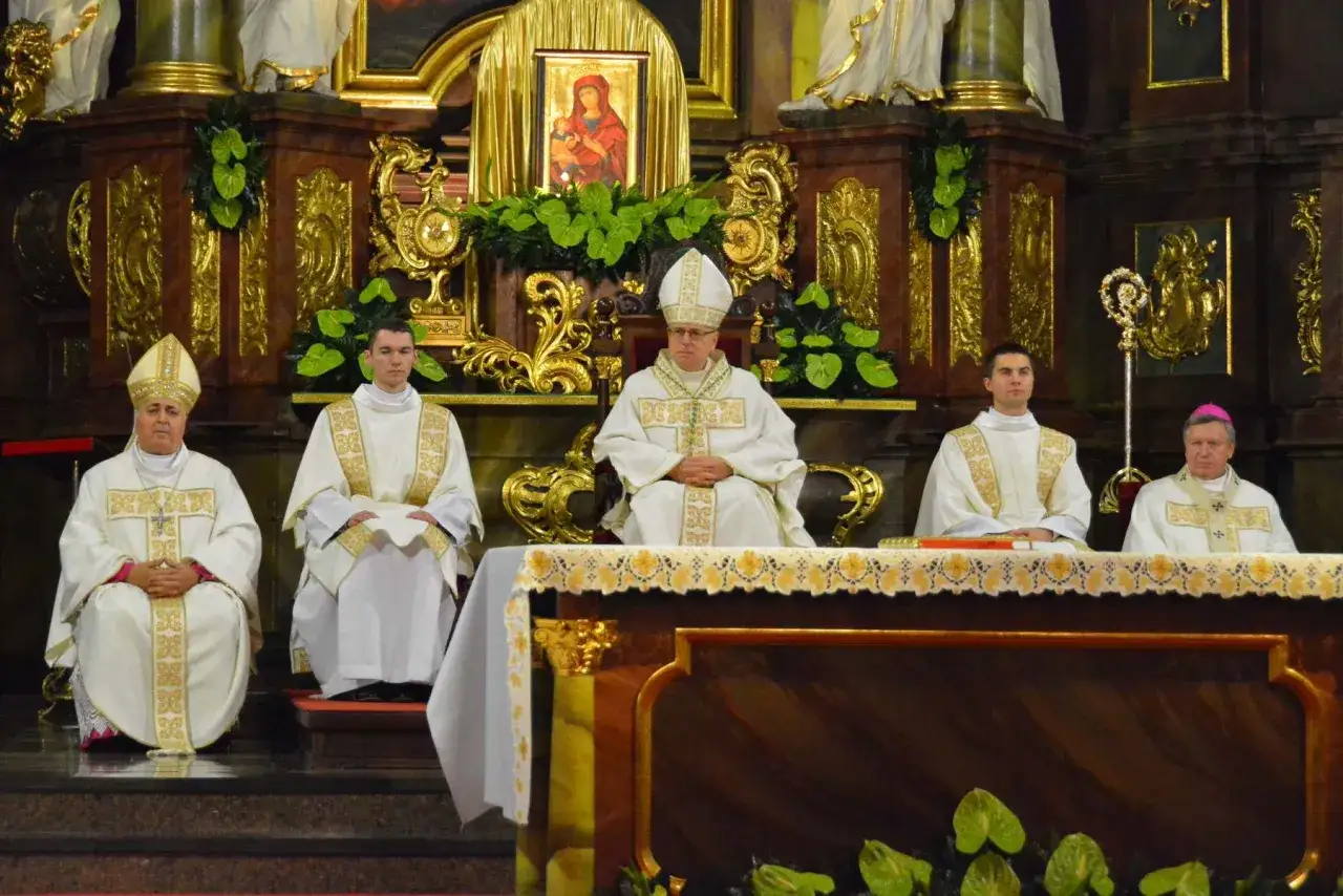 Uroczysta msza z ingressem nowego biskupa. Witraże i złote zdobienia tworzą podniosłą atmosferę.